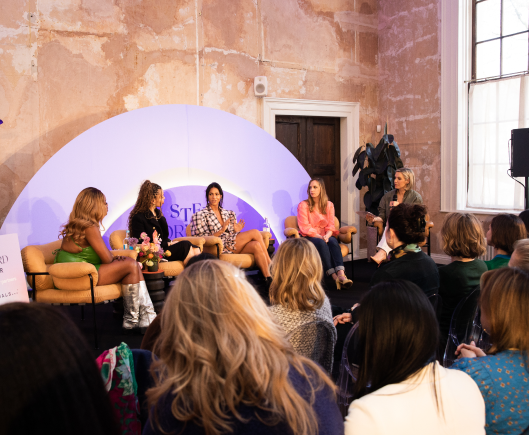 An audience sat watching a panel of speakers engaged in conversation with each other