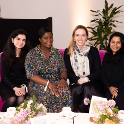 four smiling AllBright members seated on a sofa and smiling at the camera